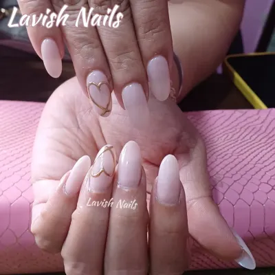 A beautiful and simple set of long, milky pink oval nails with a delicate gold heart outline on the accent nail.