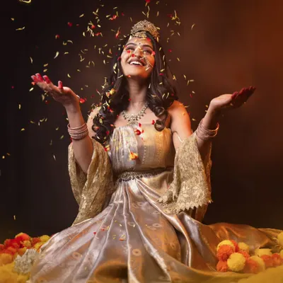 A joyful moment from our Shailaputri concept shoot. The model, styled in earthy tones and surrounded by flowers, throws petals in celebration, embodying the purity and grounded power of the goddess. This shows how styling can capture a specific emotion.