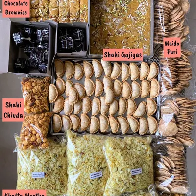 Getting ready for Raksha Bandhan with a spread of homemade sweets and snacks. This includes Double Chocolate Brownies, Mohanthal, Shahi Gujiyas, Shahi Chivda, and Maida Puri.