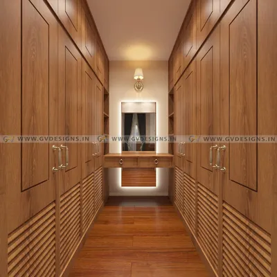 This classic walk-in closet is a teakwood masterpiece. We designed it with louvered doors for ventilation, antique-style handles, and a central dressing unit with a backlit mirror, creating a space of timeless elegance.