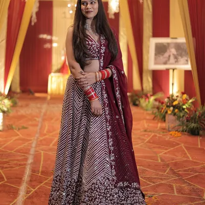 This wine-colored lehenga with chevron embroidery is a sophisticated and stylish choice for a wedding reception or sangeet.