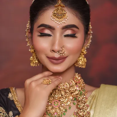 A serene look featuring one of our most popular antique temple jewellery sets. The choker and haram are adorned with Goddess Lakshmi motifs, perfect for bringing blessings to your new beginning.