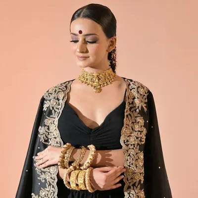 Our temple jewellery choker paired with heavy bangles creates a stunning festive look. This set gives the feel of real gold and is perfect for traditional outfits.