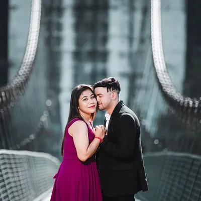 A romantic and moody shot on a suspension bridge. The cool color tones and the couple's close embrace create a very cinematic and intimate feel.