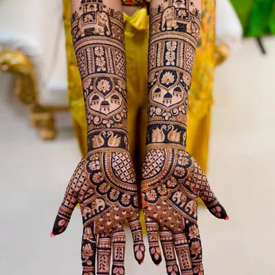 A stunning full bridal mehendi featuring royal elephants and palanquins. The bold, dark application ensures a rich stain, perfect for your wedding photos.