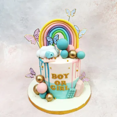 This "Boy or Girl" gender reveal cake is a whimsical masterpiece, featuring pink and blue drips, a pastel rainbow, and fluttering butterflies.