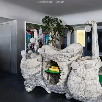 A closer look at the Monster Console, a piece of functional sculpture carved from a single marble block. The design incorporates open shelving and integrated globe lights, making it as practical as it is visually striking.
