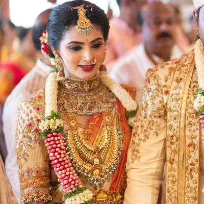 A beautiful candid moment from a wedding ceremony, with our bride looking radiant in her custom embroidered blouse and silk saree. Her traditional gold jewelry and joyful expression perfectly capture the spirit of the day.