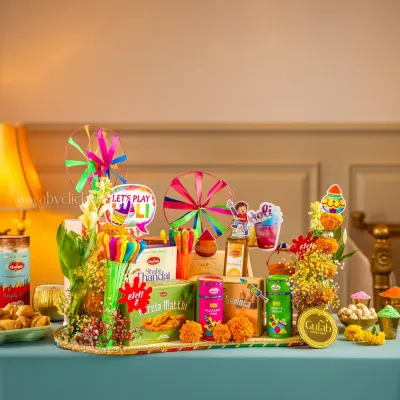 A vibrant Holi festival hamper from Gulab Sweets, filled with snacks, colors, and festive props, creating a joyful and celebratory mood.