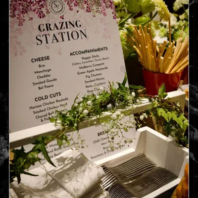 Every detail is considered in a bespoke event. This custom menu for a "Grazing Station" outlines the specific selection of cheeses, cold cuts, breads, and accompaniments, communicating the care and planning behind the spread.