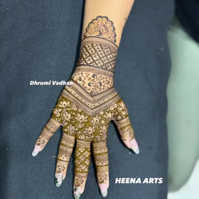 A beautiful example of a modern mehendi design. This piece uses negative space and a combination of floral and geometric patterns for a contemporary look.