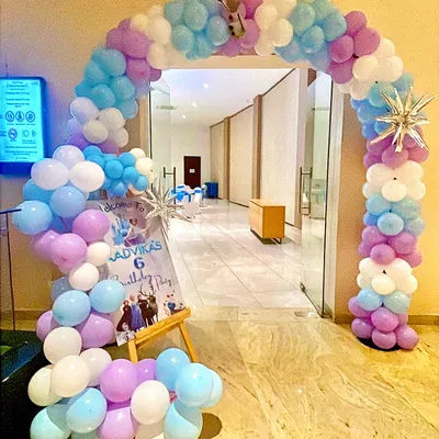 A grand entrance for a Frozen-themed party, featuring a full balloon arch in pastel blue, purple, and white. I added snowflake accents and a small Olaf cutout to welcome guests into the winter wonderland.
