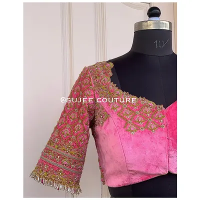 This pink velvet blouse features a sweetheart neckline and heavily embroidered sleeves. The design combines traditional zardozi patterns with a modern cut for a unique bridal piece.