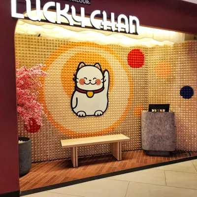 The complete entrance installation for Lucky Chan sushi parlor. We used 1,408 wooden pegs to create a textured backdrop that makes their brand mascot pop, creating a memorable welcome for diners.