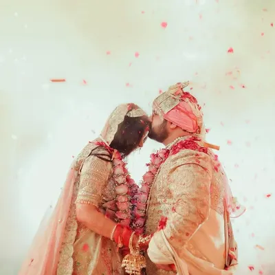 A magical moment as the couple kisses, surrounded by a shower of petals and the glow of fireworks. This is the kind of grand, cinematic shot we love to create.