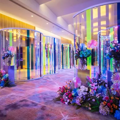 The entrance to the sangeet, where guests journeyed through a mesmerizing tunnel of iridescent panels and vibrant floral arrangements. This set the stage for a night of modern elegance and high energy celebration.