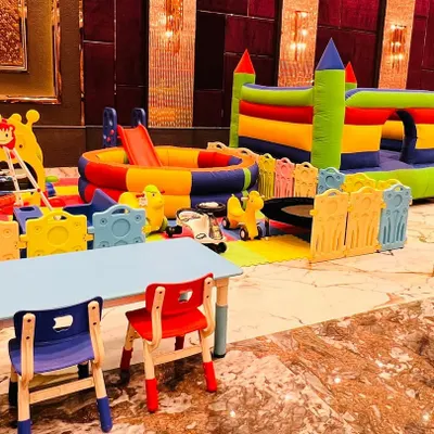 A complete soft play zone for toddlers, featuring a ball pit, slides, a bouncy castle, and kid-sized tables and chairs.