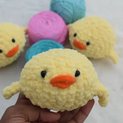 A handful of fluffy joy! This is one of my plush chick designs, held up against the yarn I use to show the raw material before it becomes a cute friend.