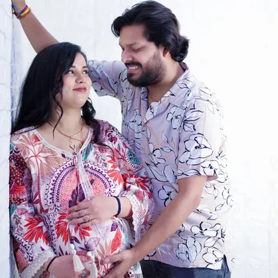 A candid and loving moment between an expecting couple. The genuine smiles and gentle touch on the baby bump make this a timeless memory of their shared excitement.