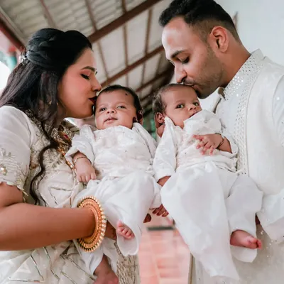 A heartwarming portrait of new parents holding their twin babies, a perfect capture of love and family.