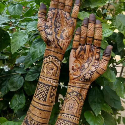 A classic and intricate full-hand bridal design, photographed against a natural green background to make the henna details pop. This pattern features traditional motifs perfect for any bride.