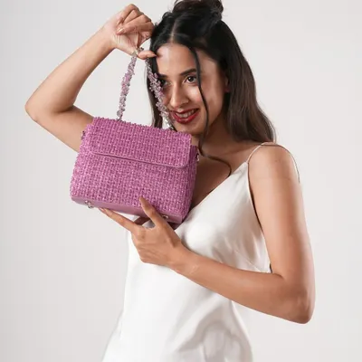 Shine like a crystal with this stunning handcrafted bag. A model holds the pink version of my crystal-beaded bag, which features a matching beaded strap for a touch of glamour.