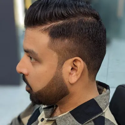 A perfect example of a sharp, modern men's haircut. The skin fade is seamlessly blended, and the beard is lined up with precision for a clean and polished finish.