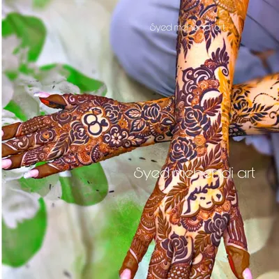An engagement henna design with personalized rings and names, looking beautiful on the client.