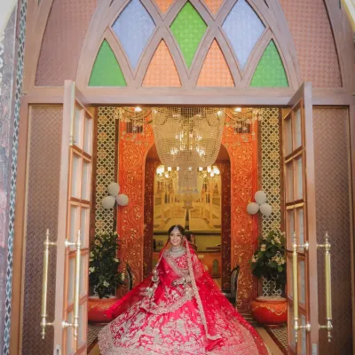 A grand bridal entry shot of Devanshi. The wide angle captures her magnificent lehenga and the opulent decor of the venue as she makes her way to her forever. This is a true statement bridal portrait.
