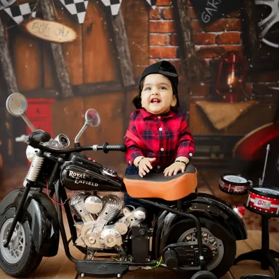 Born to be wild! This little guy is ready to hit the road in our biker-themed setup, featuring a miniature motorcycle and a cool garage backdrop.