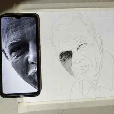 Accuracy is key to a successful portrait. Here you can see my process, where I use the grid technique to meticulously map out the proportions from the reference photo. This foundational step ensures the final hand-drawn sketch is a true and honest likeness of the person.