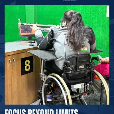 A female para-athlete takes aim with her rifle, demonstrating incredible focus from her wheelchair at our indoor facility. My adaptive training ensures every athlete can compete at their highest level.