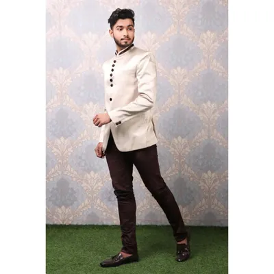 A male model in a stylish off-white bandhgala jacket and dark trousers, captured in a dynamic walking pose for a lookbook.