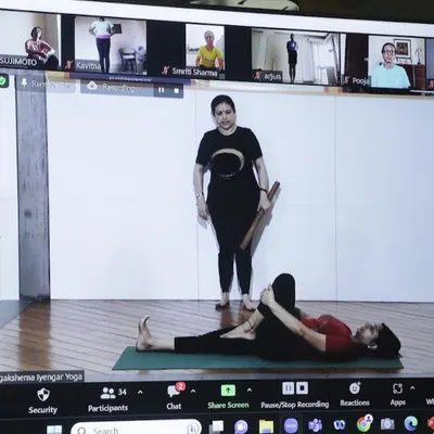 A look into my hybrid class, where I guide students both in the studio and online. Here, I am demonstrating a pose while students on Zoom follow along, ensuring everyone receives personal attention.