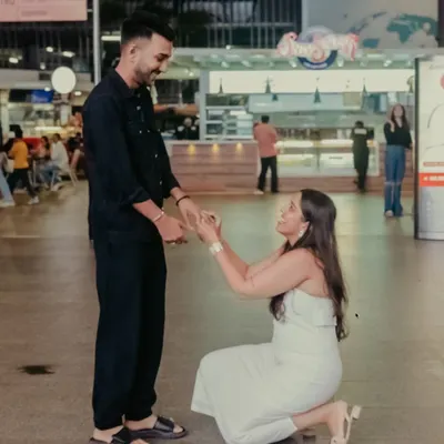 The moment Hanisha went down on one knee at the airport. Capturing a surprise proposal in a busy public space requires careful planning and discretion, allowing the moment to unfold naturally without interruption.