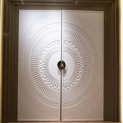 A main door should make a grand statement. This double door features a spectacular 3D-carved circular design, finished in a matte pigmented PU paint that gives it a smooth, stone-like appearance. It's a true centerpiece for any entrance.