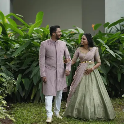 A beautiful moment between Dr. Tushara and her partner. I designed his elegant mauve Indo-Western sherwani to subtly complement the delicate embroidery on her custom half-saree, creating a harmonious look for their event.