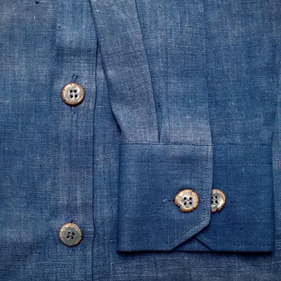 A close-up of the finished custom ceramic buttons on a hand-stitched indigo shirt. It was so rewarding to see how they provided the perfect finishing touch.
