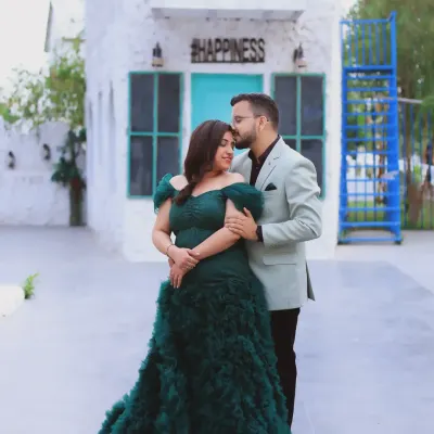 A classic couple's maternity portrait. The combination of the elegant green gown and the simple, happy backdrop makes for a beautiful and romantic photograph celebrating your journey together.