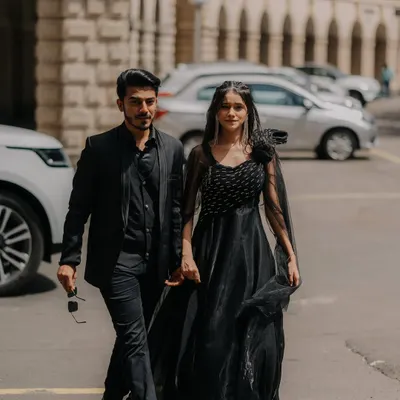 A candid, on-the-move shot of the couple walking through the streets of Mumbai. Their coordinated black outfits and confident stride give this pre-wedding photo a cool, cinematic vibe.
