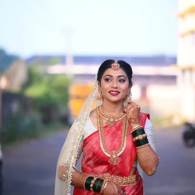 A beautiful shot of bride Bhoomika in her custom wedding attire. The contrast of the intricately embroidered white blouse against the rich red silk saree creates a timeless and elegant bridal look.