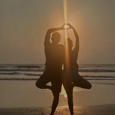 Practicing yoga with a partner is about creating something beautiful together. Here we are in a partner Tree Pose, forming a heart against the sunset to symbolize the strength and courage that comes from loving deeply.