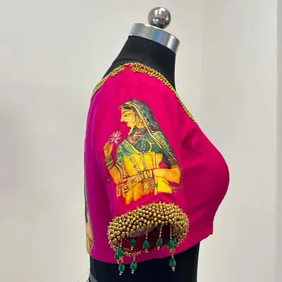 A true work of art, this pink blouse features a beautiful hand-painted motif of a traditional woman. The sleeves are adorned with beaded tassels for an extra touch of elegance.