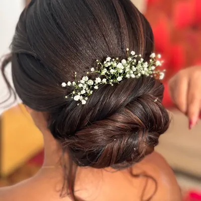 A classic bun is always a royal and elegant choice. This beautifully twisted low bun is adorned with delicate baby's breath, perfect for a reception or engagement.