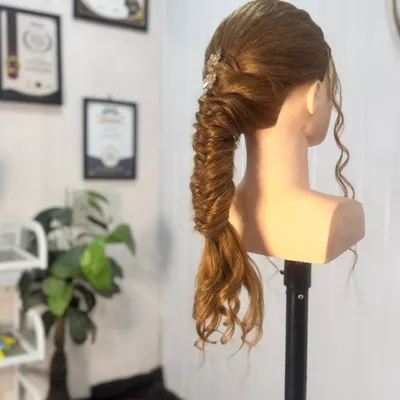 A demonstration of an intricate fishtail braid, finished with a delicate hair accessory. This style is perfect for a reception or sangeet.