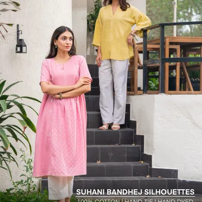 Our Suhani Bandhej silhouettes are crafted from 100% cotton and feature hand-tied, hand-dyed, and hand-embroidered details. This image showcases our pink kurta-dress and a yellow top, perfect for sunny days.