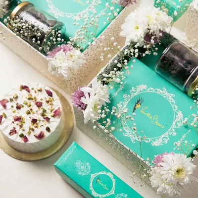 Our complete Ganesh Hamper, featuring a box of our signature Cake Mithai, assorted Cake Modaks, a jar of brownie bites, and a beautiful Rasmalai cake.