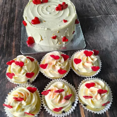 The season of love. This set includes a simple heart-themed cake and six matching cupcakes, all decorated with vanilla buttercream and tiny red hearts.