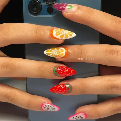 A different view of the fruit salad nails, posed against a phone to show how vibrant the colors are. Each fruit is a tiny, hand-painted masterpiece.