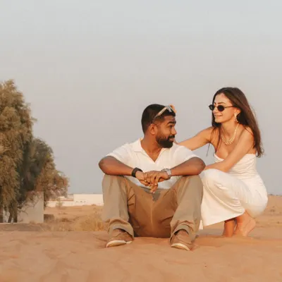 A candid moment of connection in the Dubai desert. The soft light and natural interaction showcase a relaxed and authentic pre-wedding photography style.